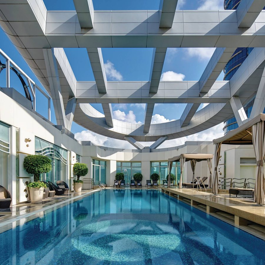 Cordis Hotel outdoor pool under blue skies and a cabana