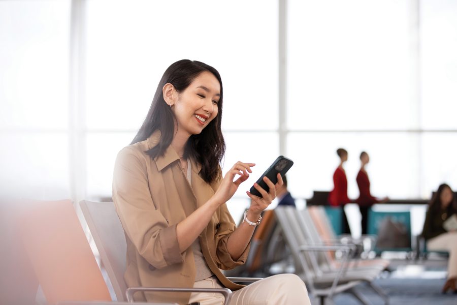 A woman checks her phone at the gate.