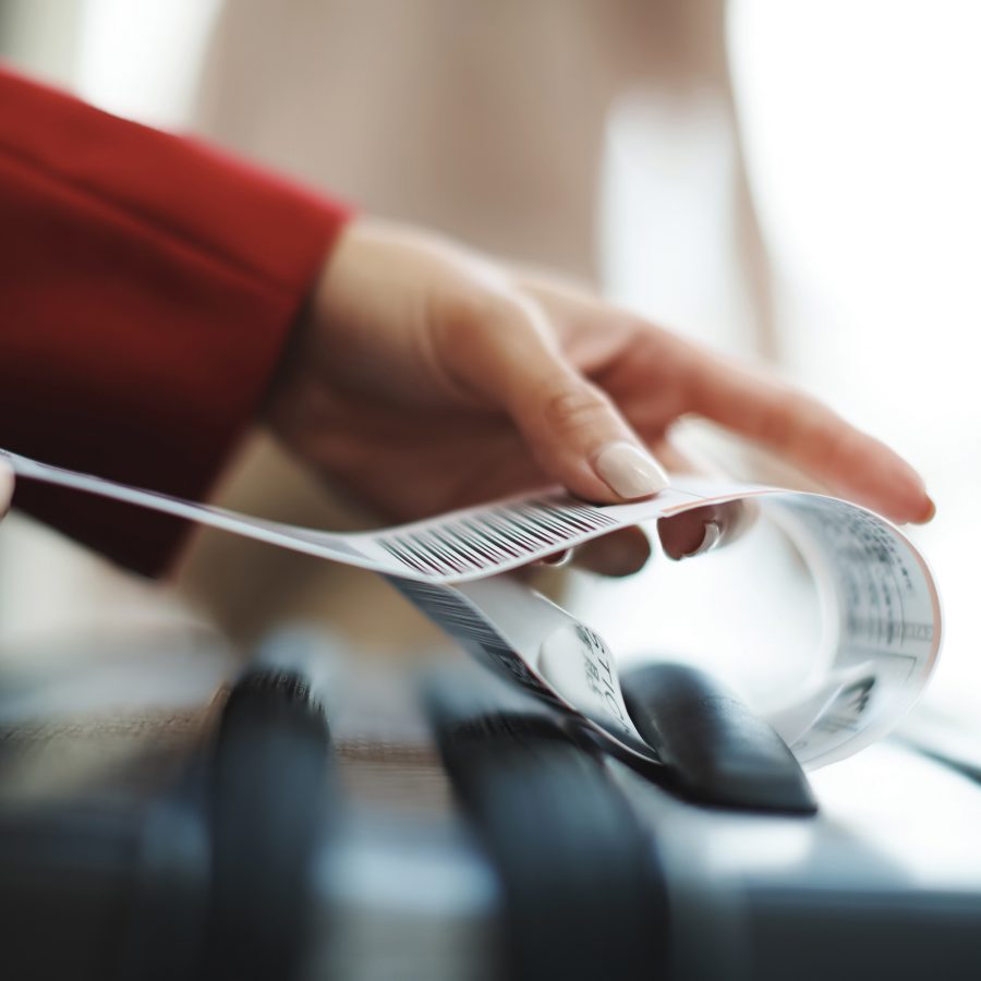 Closeup view of someone putting a tag on a piece of luggage.