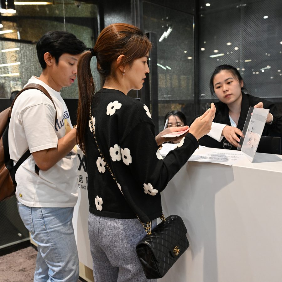 A female staff member helping a man and a woman at a counter