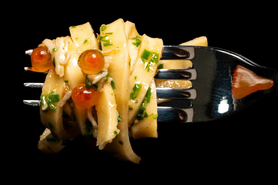 A closeup of a pasta glistening with olive oil with fish roe and parsely rolled around a fork, served at Fugazzi in Adelaide, South Australia