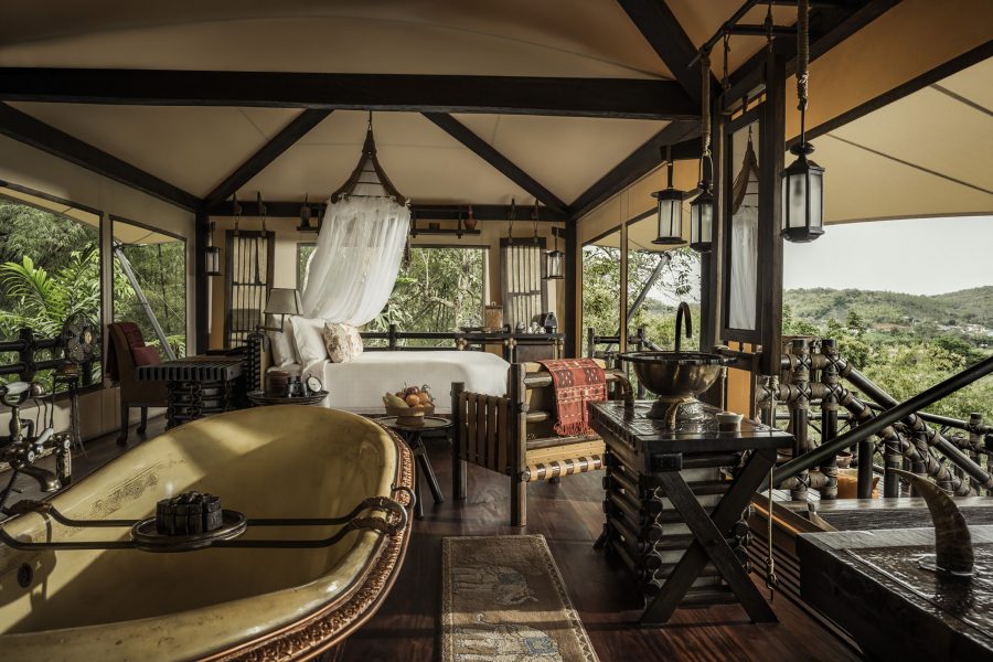 Interior of a lodging at Four Seasons Tented Camp Golden Triangle. The forest can be seen outside.