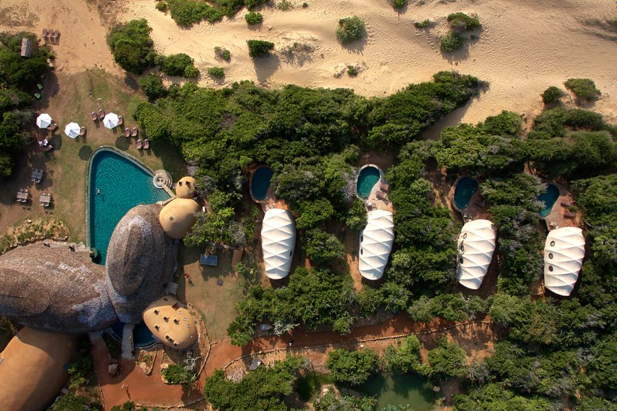 Aerial daytime view of cocoon-like accommodations and pools at Wild Coast Tented Lodge, Sri Lanka. 