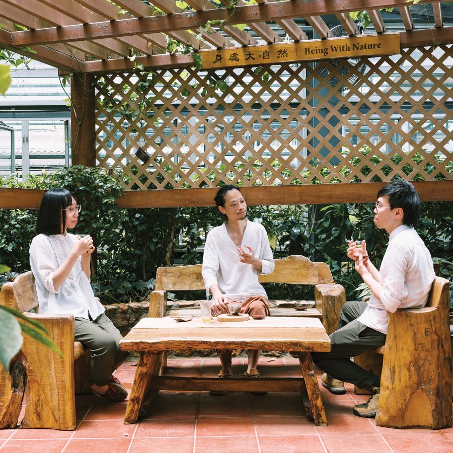 Ting, Lamlam and Season of the Hong Kong Tea  Production Institute sit and have a cup of tea together on wooden furniture