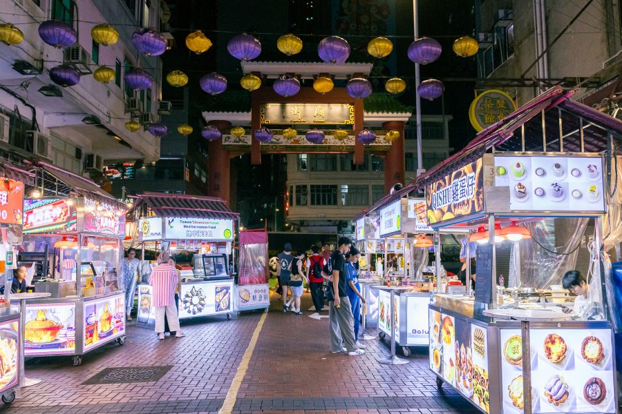 A street view of Temple Street night market and food vendors with vibrant lanterns overhead in Jordan, Hong Kong 