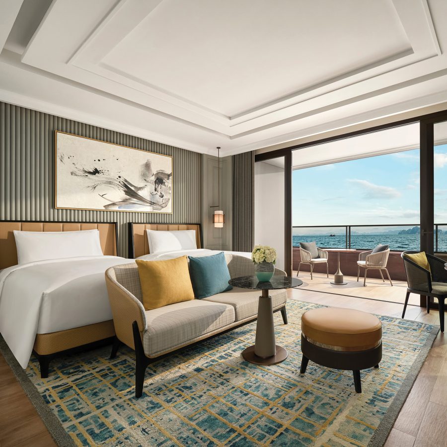 A twin classic bedroom at the InterContinental Halong Bay Resort with an outdoor terrace that overlooks the sea.