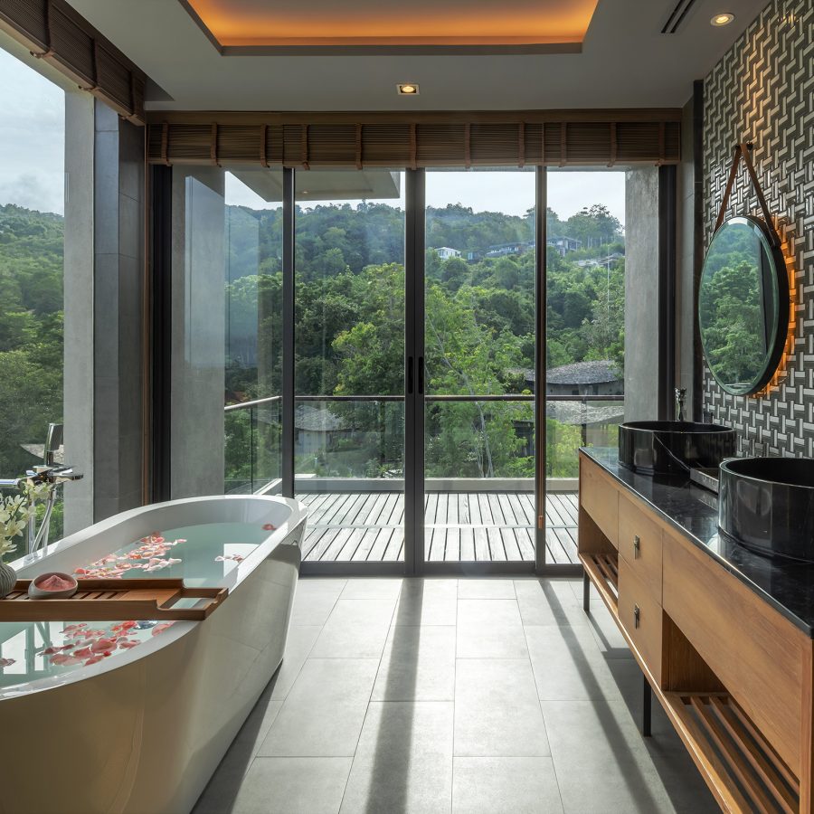 The bathroom of a private loft at Noku Phuket, with a bathtub and outdoor terrace.