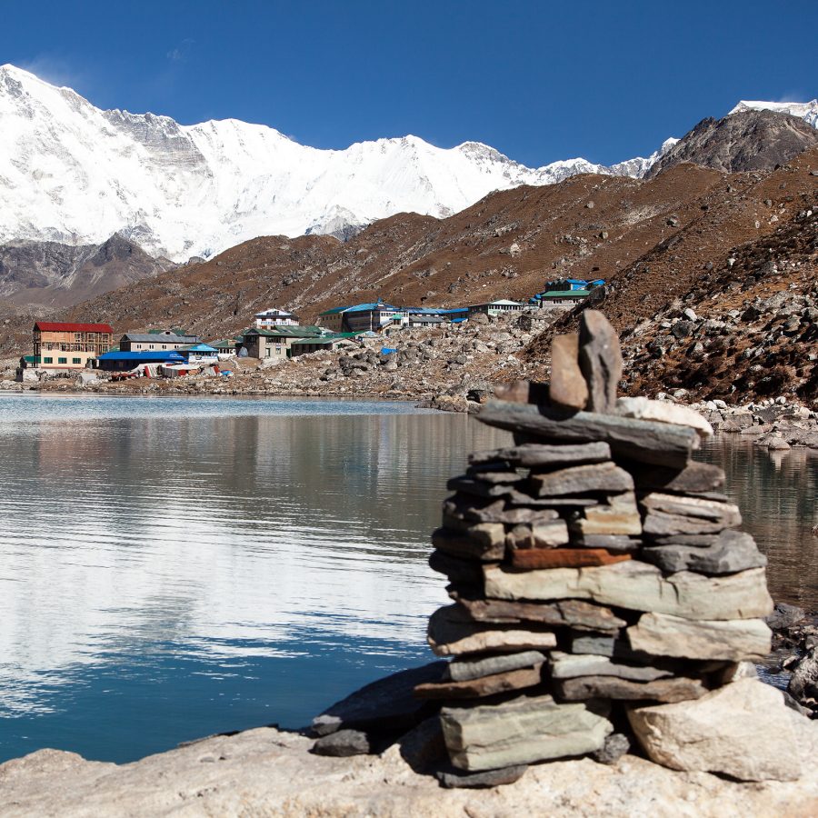 A stack of rocks has been placed on the edge of one of the Gokyo Lakes in the Himalayas. 