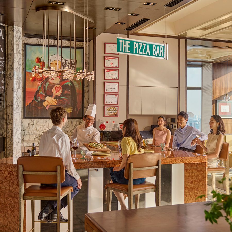 A chef serving a group of diners around a bar top at The Pizza Bar inside the Mandarin Oriental, Tokyo