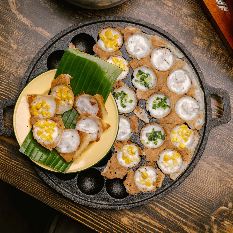 A cast iron dish filled with small white circular bites at Thai restaurant Siaw in Hong Kong.