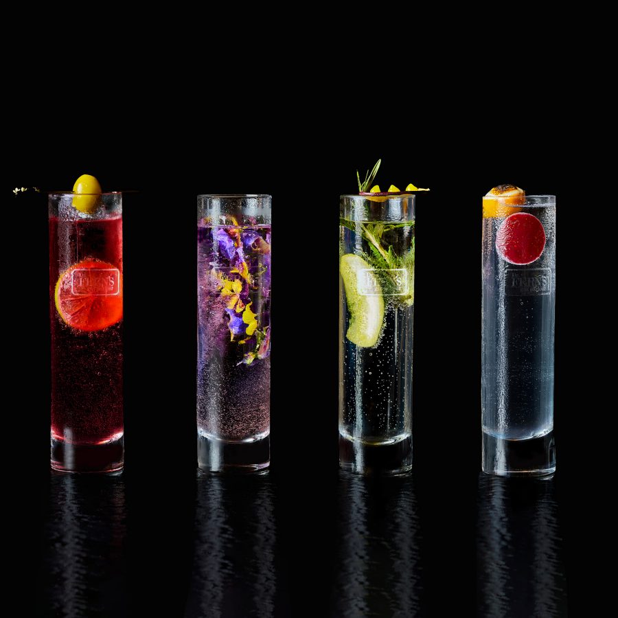 A row of tall narrow cocktail glasses filled with different fruits and garnishes at The Doctor’s Residence.