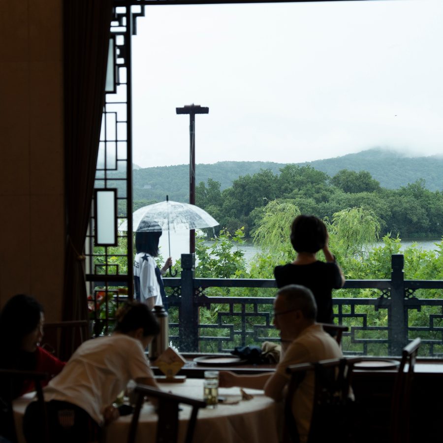 Interior view of Lou Wai Lou, with water and mountains in the background.