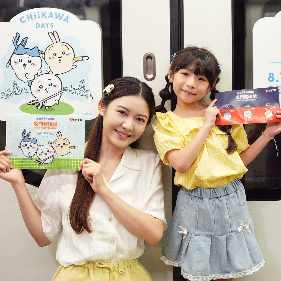 A woman and a young girl hold up Chiikawa-themed pictures underneath Chiikawa Days posters in Hong Kong.  