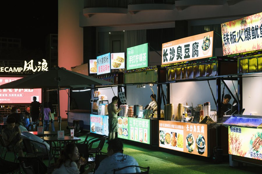 A view of people eating outdoors alongside various street food   stalls at Yanmei Road Night Market in Xiaomeisha, Shenzhen