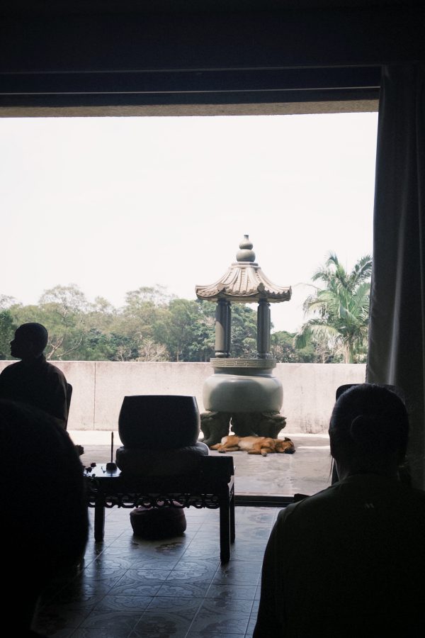 A monk sitting by an open doorway at the Lotus Pond Temple in Ngong Ping. 