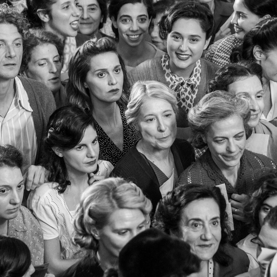 A black-and-white image of a crown of women dressed in 1940s attire, in a scene from the film There’s Still Tomorrow.