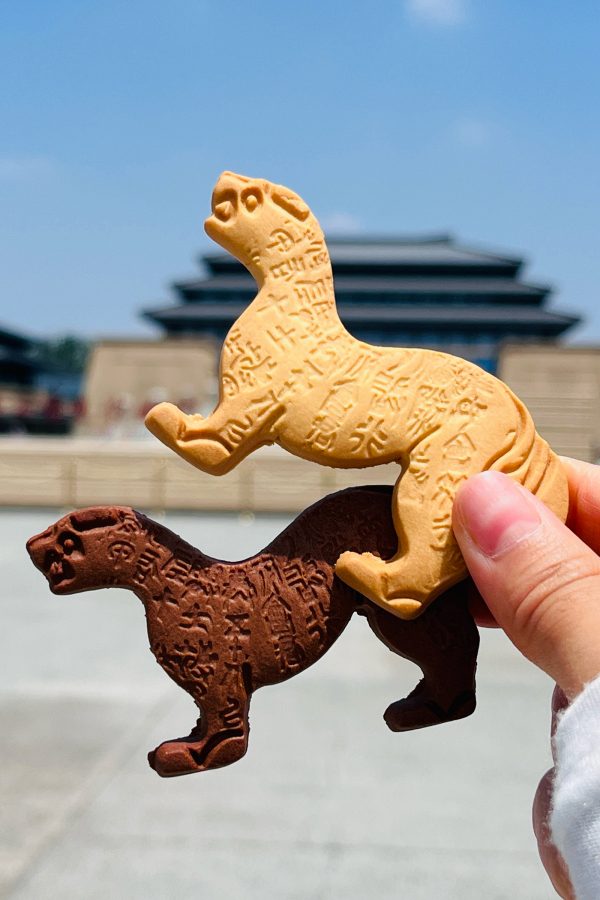 Person holding up two tiger-shaped cookies from Shaan Pastry.