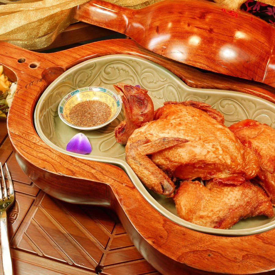Close up on a Hulu chicken dish in a violin-shaped plate.