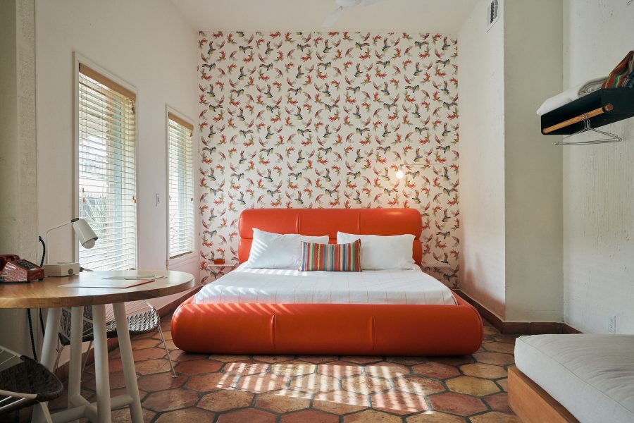 A stylish cream and orange guest room at Austin Motel. 