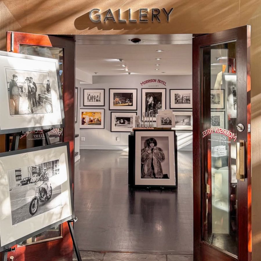 Entrance to a brightly lit gallery exhibiting large photo portraits of famous pop culture figures.