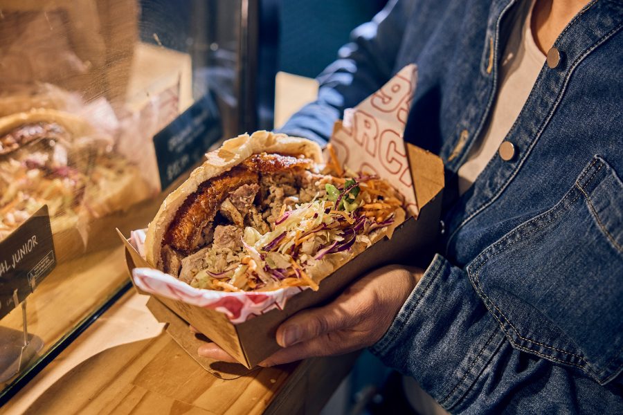 A diner holds a wrap filled to the brim with toppings at Adelaide Central Market.  