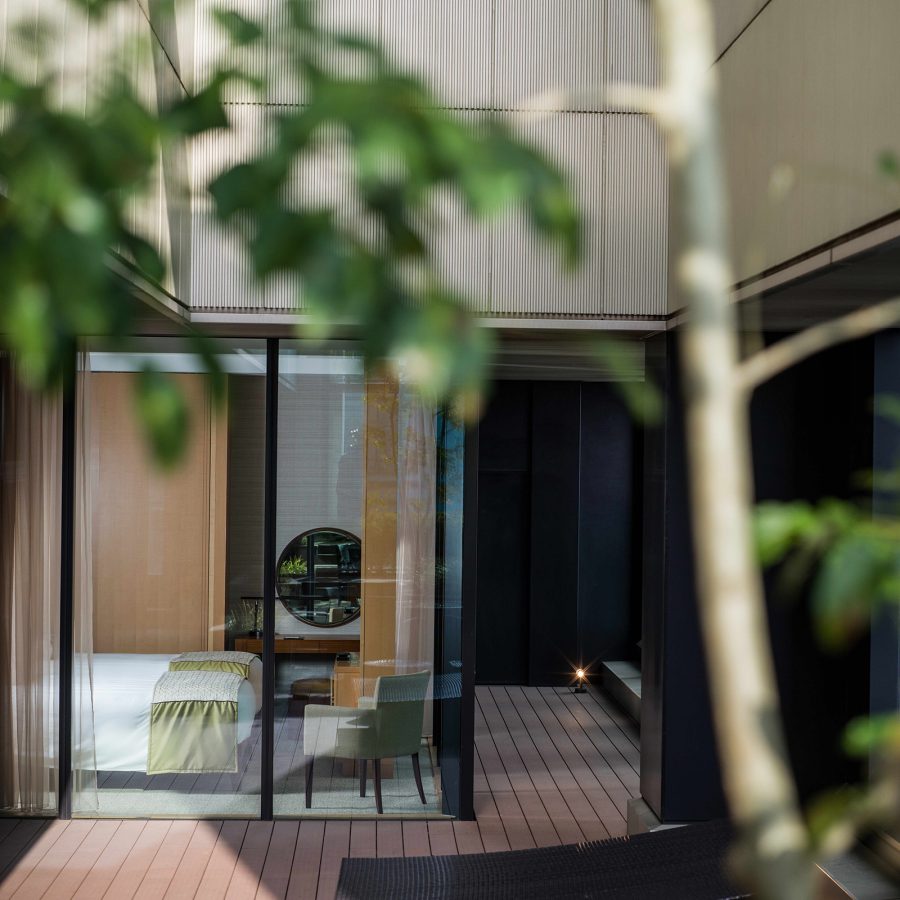 A view of the Intercontinental Osaka suite seen from behind a tree at an outdoor terrace.