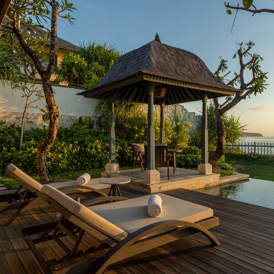 A view of a garden pool with outdoor lounge chairs and a gezebo at Jumeirah Bali resort.