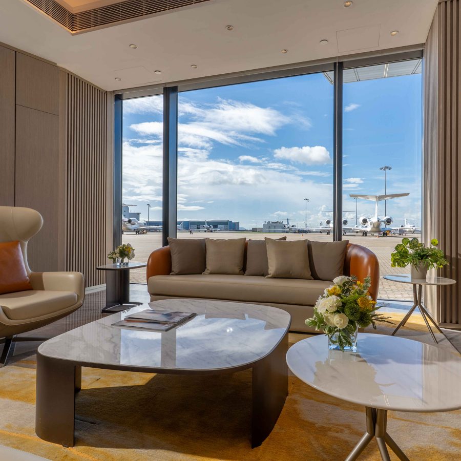 An interior view of HKBAC lounge with floor-to-ceiling windows and a view of the tarmac