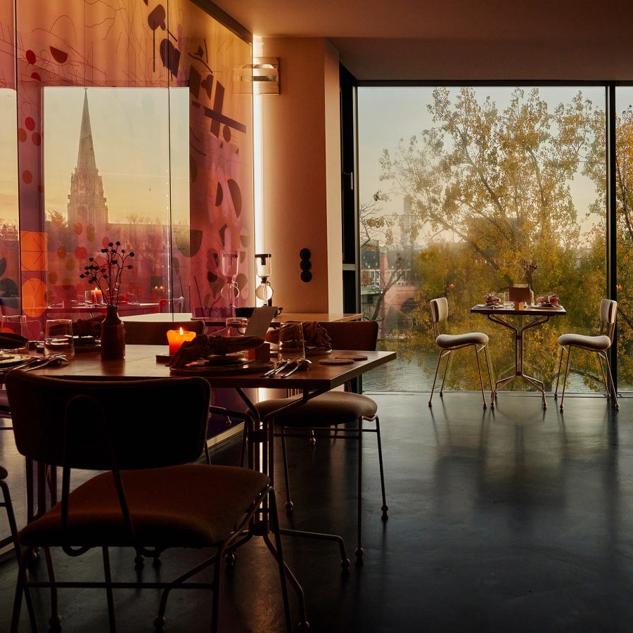 Interior view of Seven Swans restaurant in Frankfurt, with the Main river outside the large window.