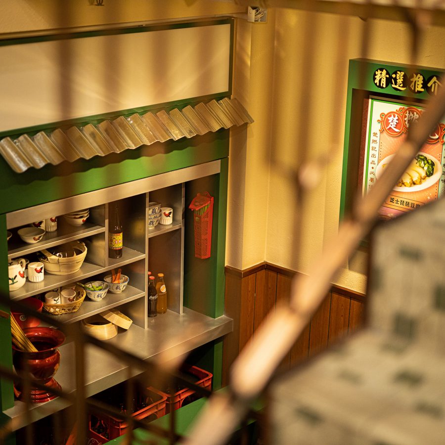 The nostalgic decor of ChorLand Cookfood Stall is seen through a staircase railing. 
