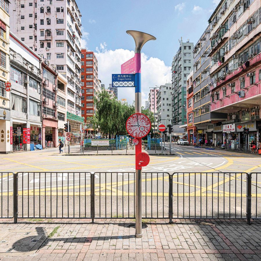 A signpost with an AR clock stands in the middle of the street in Sham Shui Po.