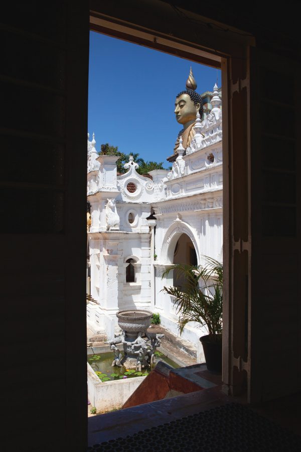 A view of Wewurukannala Vihara temple in  Sri Lanka, seen through a window frame during the daytime