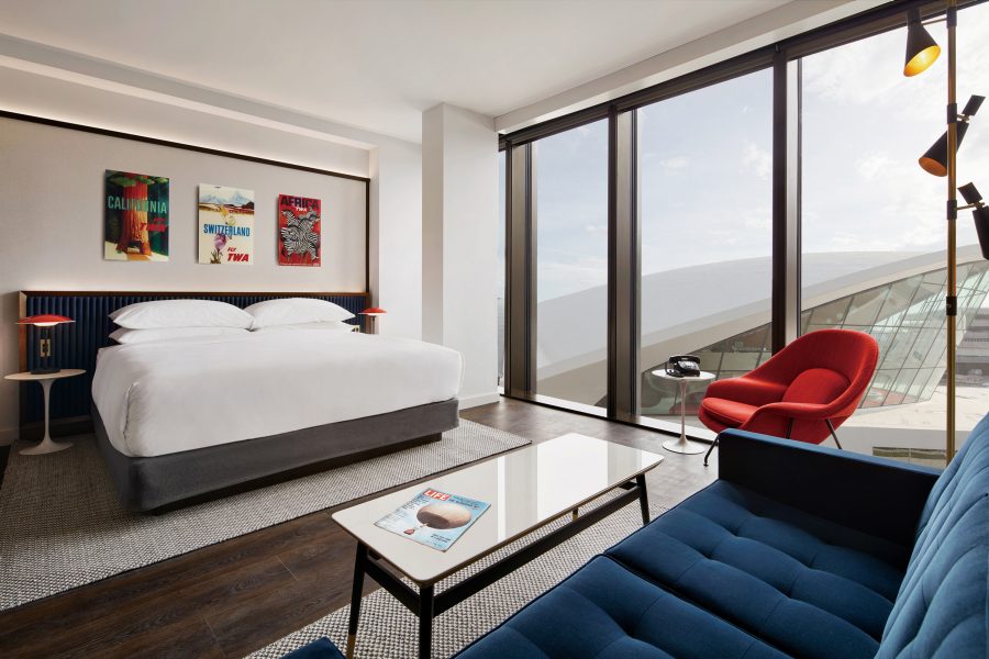 A guest room at TWA Hotel is equipped with sleek chairs, lamps and artwork.