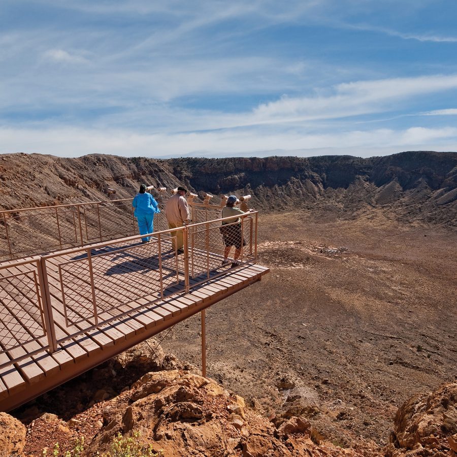A group of people walking on a bridge over the Meteor Crater near Winslow, Arizona.