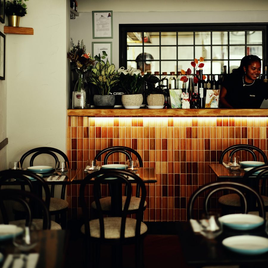The interior of Nocino is decorated with warm-coloured tiles and plants hanging from walls. 