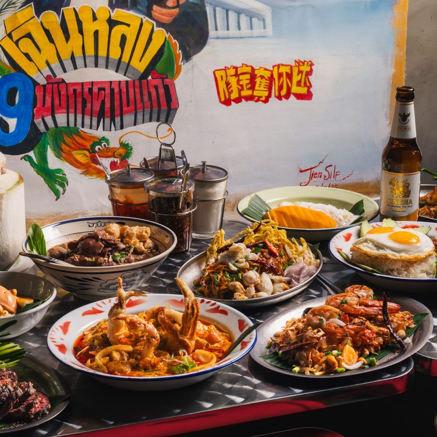 A spread of dishes has been lain out at Thonglor in front of a colourful wall. 