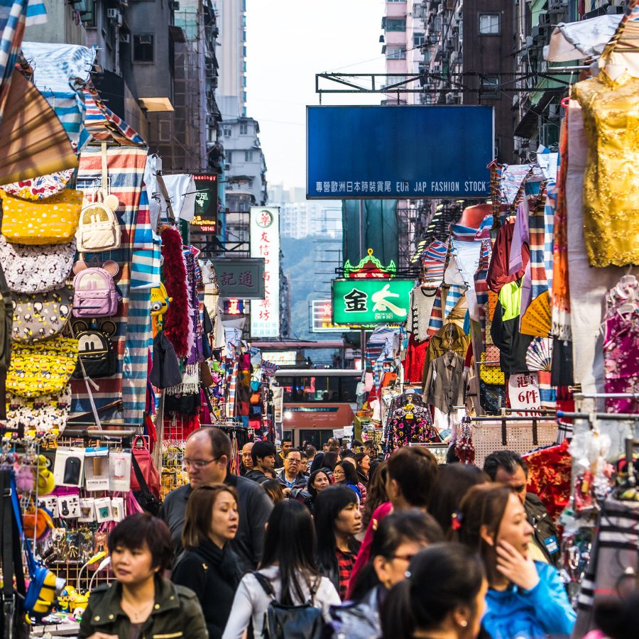 A crowd of shoppers walking through the busy stalls at Ladies’ Market with a variety of clothes, bags and souvenirs on display in Mong Kok, Hong Kong