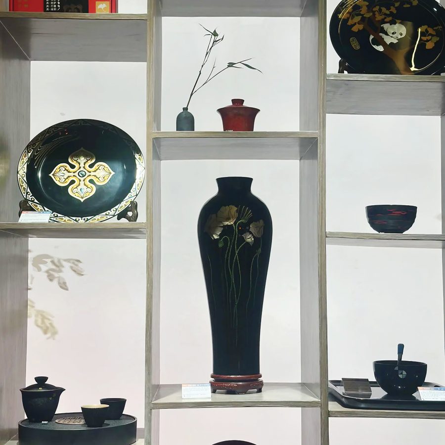 Examples of Chengdu lacquerware plates, vases and more styled on white shelves