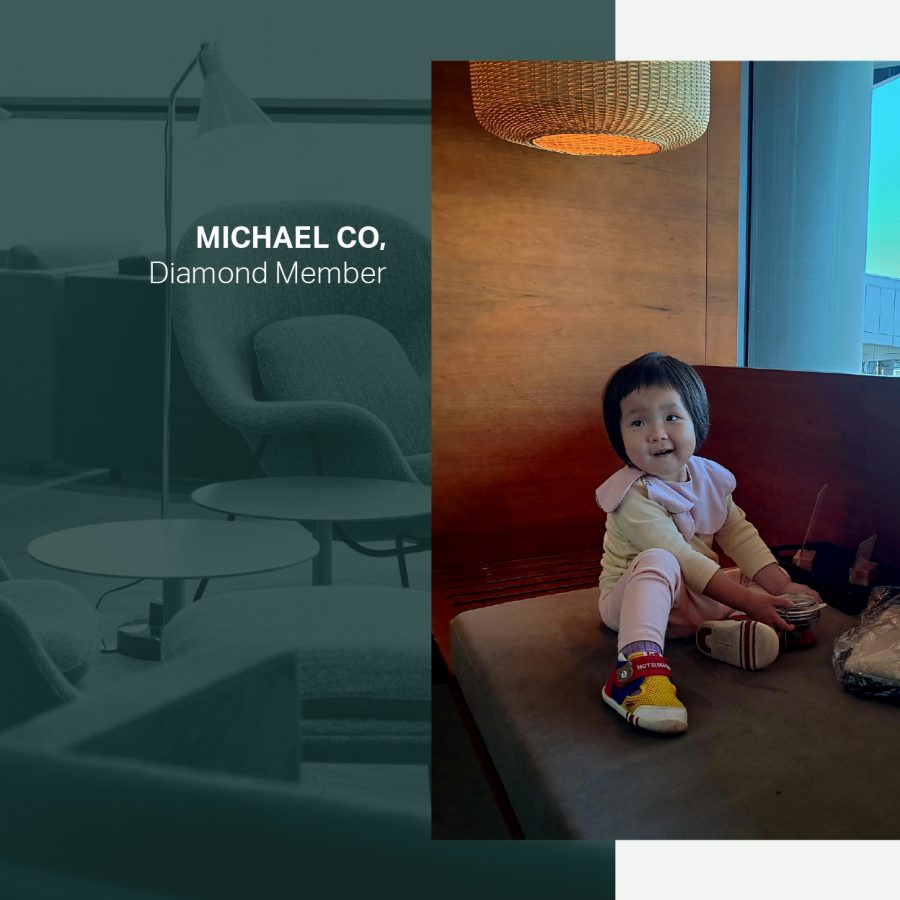 A smiling toddler sitting on a sofa by the window at Cathay Pacific’s The Pier, First lounge at Hong Kong International Airport.