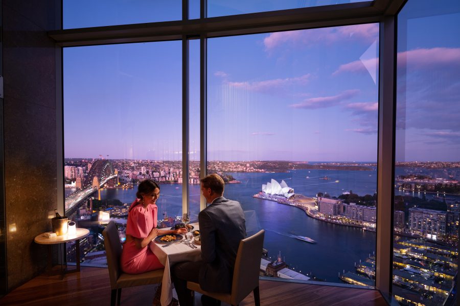 A couple enjoy a dimly lit dinner overlooking Sydney Harbour at Shangri-La Sydney.