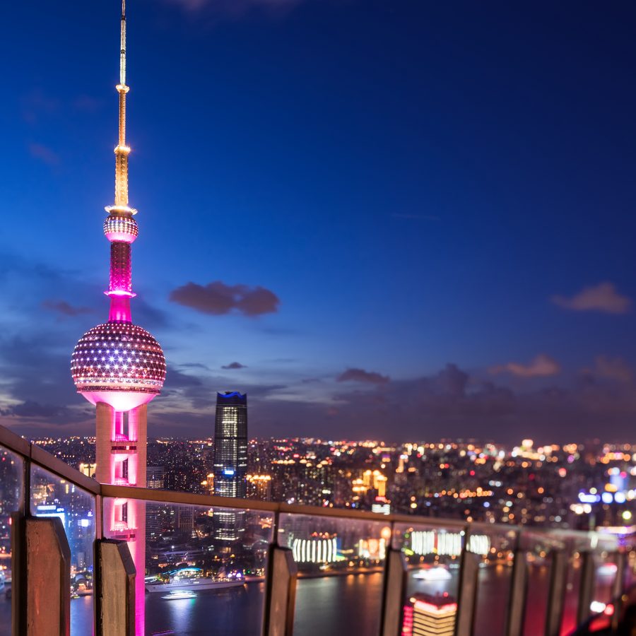 A view of the neon lit Oriental Pearl TV Tower at night and Shanghai’s skyline seen from the rooftop of a bar