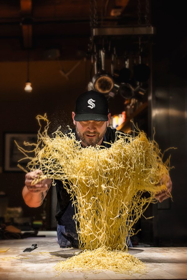 Man tosses a huge pile of pasta at Pike Place Market in Seattle.