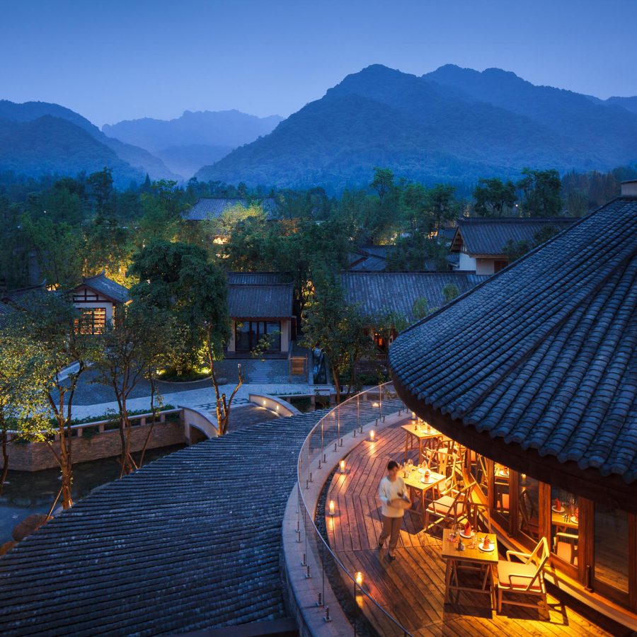 Circular buildings with sloping roofs are set against the mountains in the distance at Six Senses Qing Cheng Mountain.