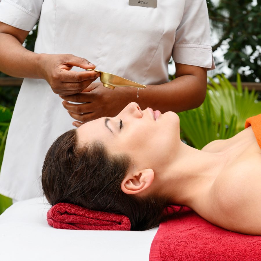  A woman lies face up outdoors and receives a welless treatment at Ananda in the Himalayas.