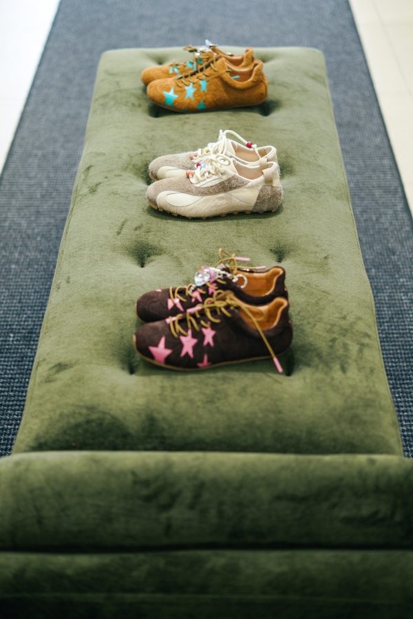 Shoes sit perfectly spaced between one another on a green velvet couch at Side in Guangzhou.  
