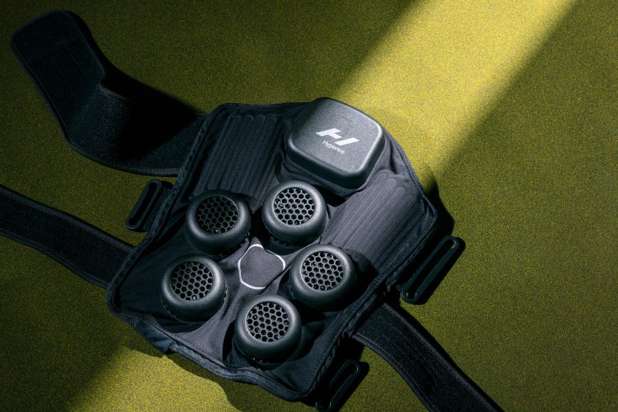 Product shot of the Hyperice X Knee against a green backdrop.
