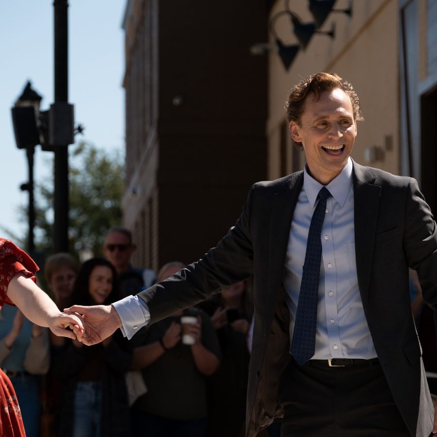A man and woman hold hands and laugh while walking down a street in a scene from Life of Chuck