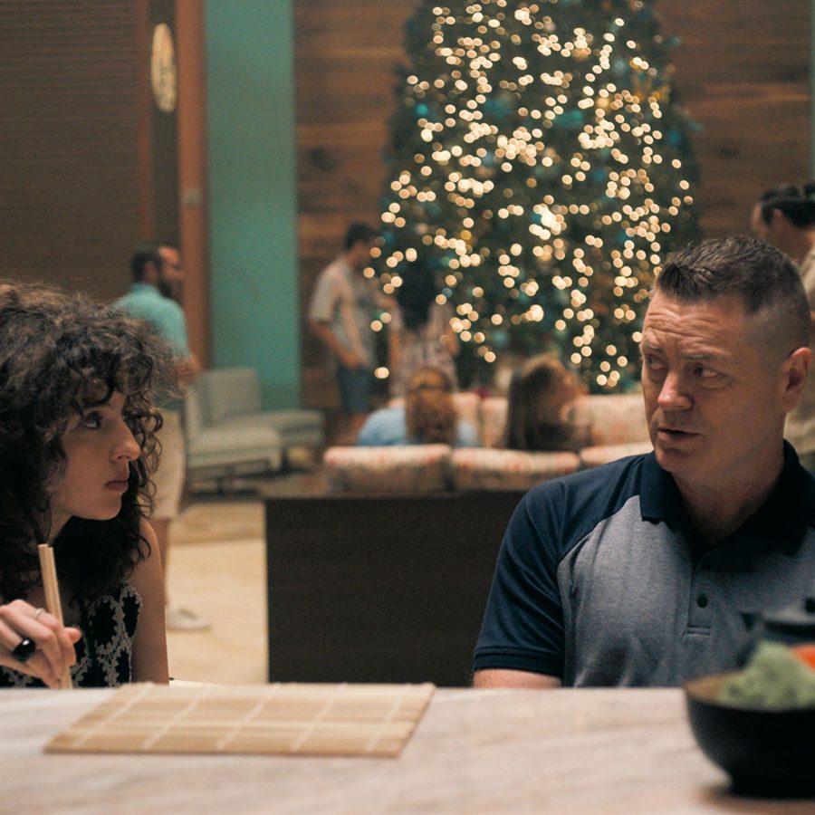 In a scene from The Resort, man and woman dine at a counter in a stylish hotel lounge
