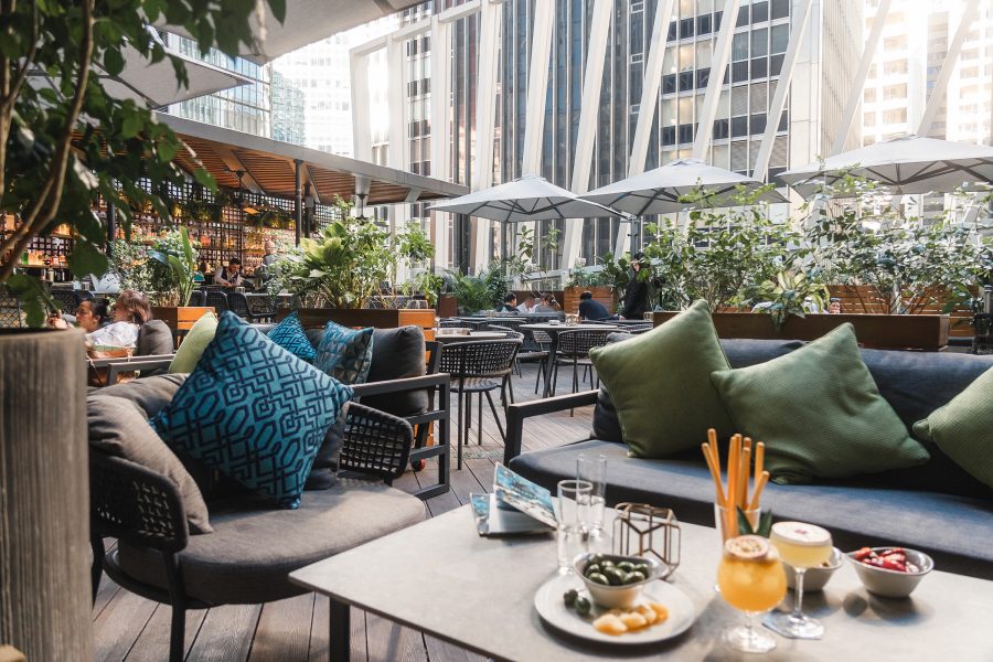 The exterior of SPIGA features outdoor cushioned seating arranged around low tables.