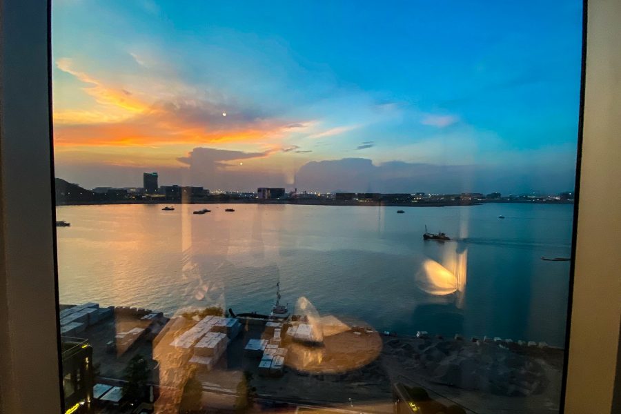 View of airport through window with boats on calm water.